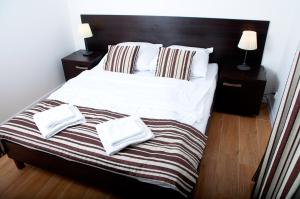 1 dormitorio con 1 cama y 2 toallas blancas en Apartament IKAR przy morzu w kompleksie LAOLA z ogródkiem en Pobierowo