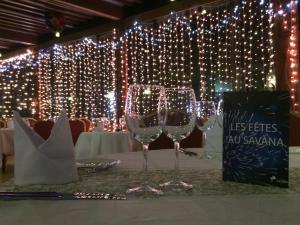 two wine glasses sitting on a table with lights at Hotel Jardin Savana Dakar in Dakar +110 photos