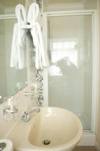 W łazience znajduje się umywalka, lustro i ręczniki. w obiekcie Merkister Hotel w mieście Harray