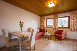 uma sala de estar com uma mesa e um sofá vermelho em Steinlechner-Meyer Elisabeth em Stumm