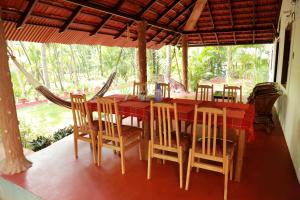 a dining room with a red table and chairs at Ocean Green Kerala in Kannur