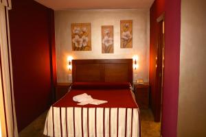 - une chambre avec un lit et une serviette dans l'établissement Apartamentos la Fuente, à Cordoue