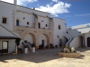 a large stone building with a clock on it at Masseria Casamassima agriturismo in Ostuni