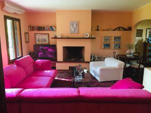 a living room with a pink couch and a fireplace at Opera Deluxe in Ravenna