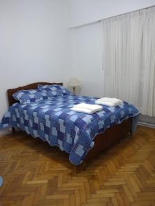 ein Schlafzimmer mit einem Bett mit einer blauen und weißen Decke in der Unterkunft Vidt 2001 Alto Palermo in Buenos Aires