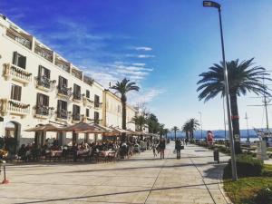 a street with tables and chairs and a building with palm trees at Apartment Sea&Sky in Tivat