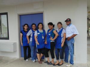 un groupe de personnes portant des gommages bleus debout devant un bâtiment dans l'établissement Motel 6 Denton, TX - UNT, à Denton