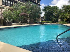 a large swimming pool with a hose in a building at Brownes Condominium 1 in Bridgetown