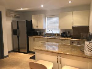 a kitchen with white cabinets and a stainless steel refrigerator at Brownes Condominium 1 in Bridgetown