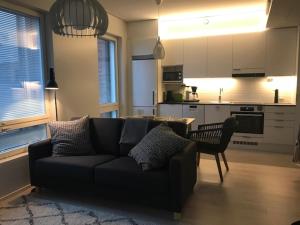 a living room with a couch and a kitchen at PikkuParlamentti in Pori