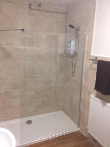 W łazience znajduje się prysznic ze szklanymi drzwiami. w obiekcie Good Intent Rooms w mieście Waltham Abbey
