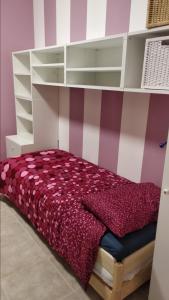 Schlafzimmer mit einem Bett mit einer rosa und weißen Wand in der Unterkunft B&B Rossini in Augusta