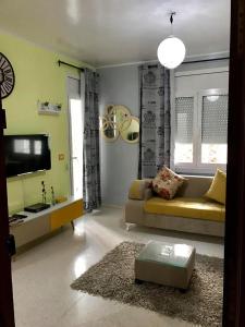 a living room with a couch and a tv at Apartment Tunis 2 Near airport in Ariana