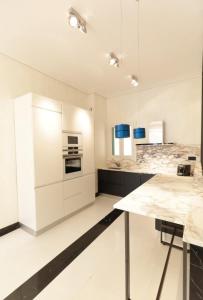 カンヌにある110 m2 golden square, renovated, 20metres croisette, parking privateの白いキャビネットとテーブル付きのキッチンが備わります。
