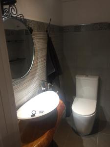 a bathroom with a toilet and a sink and a mirror at Apartamentos El Greco in Toledo