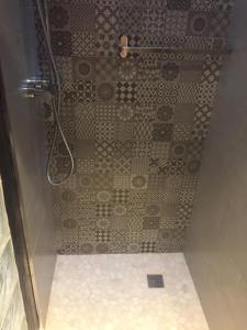 e bagno con doccia e parete piastrellata. di Apartamentos El Greco a Toledo