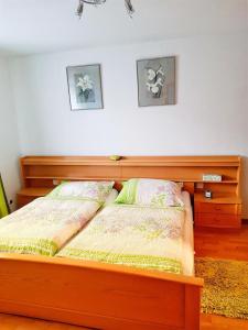 ein Schlafzimmer mit einem Holzbett mit zwei Kissen in der Unterkunft Ferienwohnung Lackner in Rennweg