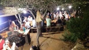 Une foule de personnes assises aux tables d'une fête dans l'établissement Ecoparco Neulè, à Dorgali