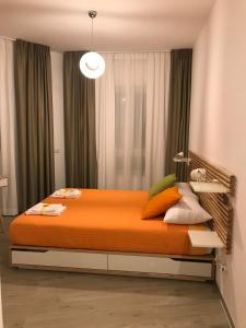 um quarto com uma cama grande e um cobertor laranja em A Matera "Sotto i pini" em Matera