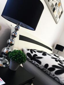 eine Lampe auf einem Tisch neben einem Bett in der Unterkunft Apartment "La Lucia" in Schwäbisch Gmünd