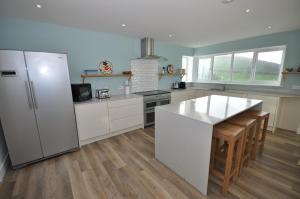 a kitchen with a refrigerator and a counter top at Seascape in Croyde