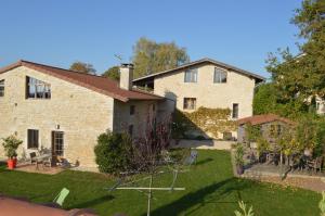 a large stone house with a yard in front of it at GITES LES MAISONS ROUGES in Jasseron