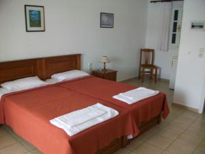 a hotel room with two beds and two lamps at Nicolas Rooms in Fiskardo