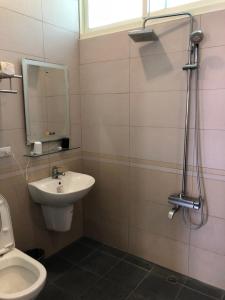 een badkamer met een wastafel, een toilet en een spiegel bij Kai Cheng Inn 旅館134 in Jiaoxi