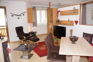sala de estar con mesa, sillas y TV en Haus Juen, en Tulfes