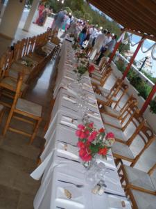 a long white table with flowers on top of it at Nicolas Rooms in Fiskardo