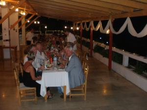 un grupo de personas sentadas en una mesa en un restaurante en Nicolas Rooms, en Fiskardho