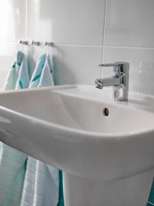 a white sink in a bathroom with blue towels at Ferienhaus Wittig in Löbnitz