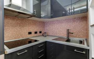 uma cozinha com armários pretos e um lavatório em Appartamenti Volta em Como
