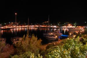 a harbor at night with boats in the water at Nicolas Rooms in Fiskardo