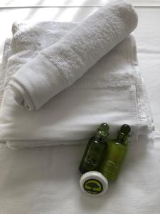 una toalla y dos botellas de jabón en una cama en Paralio Astros en Parálion Ástros