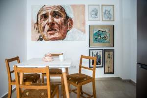 利馬索爾的住宿－At the very heart of Limassol centre, ap. 201，一间用餐室,配有白色的桌椅和绘画作品