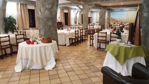 un restaurante con mesas y sillas blancas y buscador de mesa en Hotel Ristorante La Campagnola, en Cassino