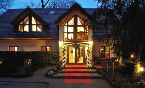 una casa con un tappeto rosso che porta alla porta d'ingresso di Hotel am Katharinenholz a Potsdam