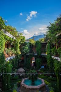 un jardín con una fuente frente a un edificio en Hotel Genessis en Antigua Guatemala