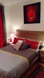 a bedroom with a bed with red and brown pillows at Chez Mag in Lille