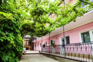 a pink house with a balcony and trees at Guest House Bashnya in Sevastopol
