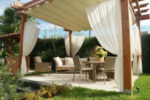 a patio with a table and chairs under an umbrella at Bivano Villa Grazia in Fondachello