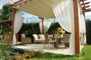 patio con tavolo e sedie sotto ombrellone di Bivano Villa Grazia a Fondachello