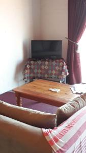 a living room with a coffee table and a couch at Jack's Seaview Inn in Bettyʼs Bay