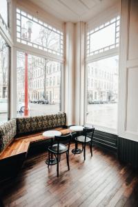 a restaurant with two tables and a couch and windows at The Society Hotel in Portland