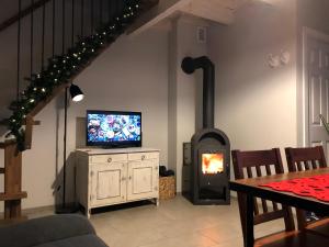 a living room with a tv and a fireplace at Domek na Leśnej in Pogorzelica