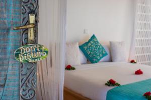 a bedroom with a bed with a dont disturb sign on it at Zanbluu Beach Hotel in Kiwengwa
