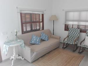 ein Wohnzimmer mit einem Sofa und einem Tisch in der Unterkunft Sa Cala Beach House in Cala Figuera