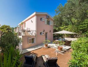 a house with a table and chairs and an umbrella at Charming Mokalo Seaside House next to Beach in Orebić