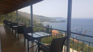 Un balcón con mesas y sillas y vistas al océano. en Fatiras Studios, en Kassiopi